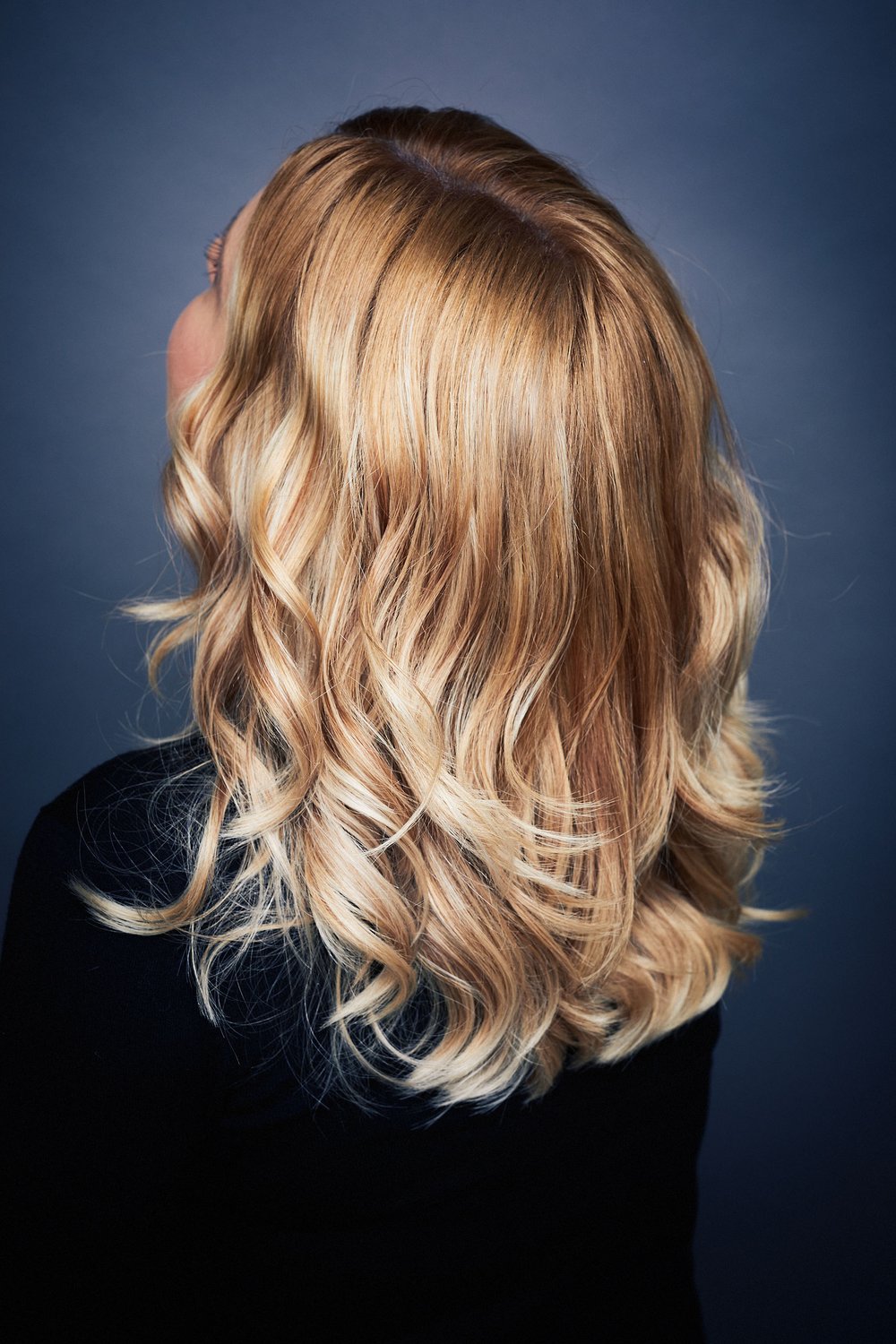 Blondes, gewelltes Haar mit feinen Farbnuancen – Rückansicht.